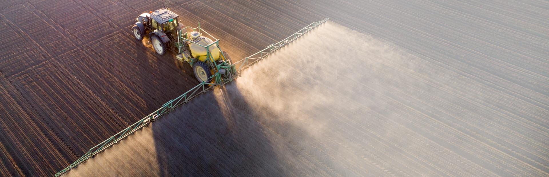 Traktor na polu spryskujący rośliny - Slajd 3